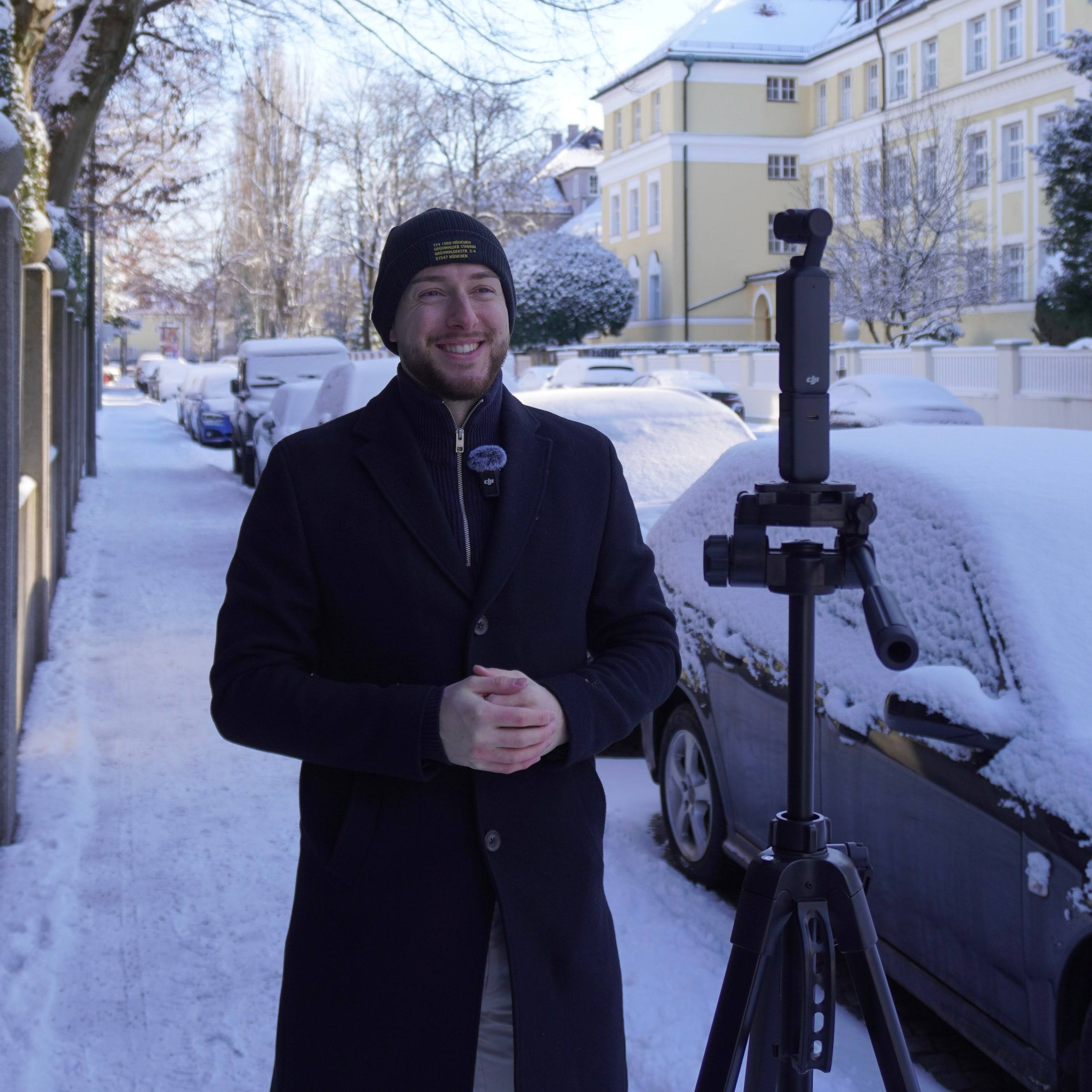 Tim Marco filmt sich mit Kamera und Stativ im Schnee für seinen YouTube-Kanal